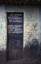 INDIA, Goa, Chapora , Narrow wooden temple door with painted inscription