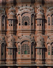 INDIA, Rajasthan, Jaipur, Palace of the Winds. Detail of orange and white carvings