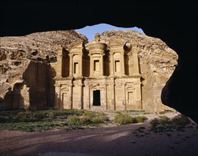JORDAN, Petra, The Monastery carved from rock face framed by rock arch.