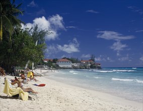 BARBADOS, Christchurch, Sunbathers on sandy beach