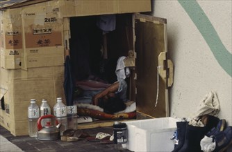 JAPAN, Honshu, Tokyo, Homeless man living in a cardboard box