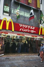 JAPAN, Honshu, Tokyo, McDonalds fast food restaurant with customers and sign above written in
