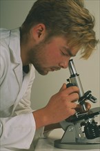 HEALTH, Science, Technichian looking through a microscope