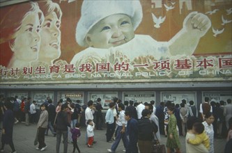 CHINA, Sichuan Province, Chengdu, Busy street with pedestrains walking past family planning poster