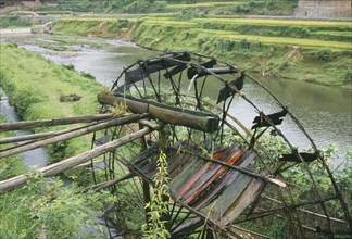 CHINA, Guangxi, Bamboo water wheel on the edge of a river.