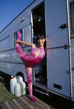 ENTERTAINMENT, Circus, Acrobat, Female acrobat in pink bodysuit in arabesque position in doorway of