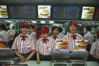 CHINA, Beijing, McDonalds staff standing behind the counter.