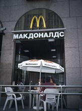 RUSSIA, Moscow, McDonalds Restaurant with people sitting at table and chairs with umbrella outside