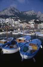 ITALY, Campania, Capri, Marina Grande harbour with fishing boats moored in front of buildings with