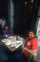 CUBA, Havana, "Bodequita del Medio Bar with two men sitting at a table covered in semi finnished