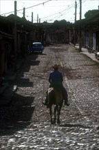 CUBA, Sancti Spiritus, Trinidad, Man riding horse on cobbled street
