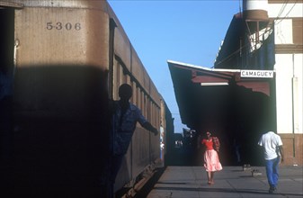 CUBA, Camaguey, Station platform with train standing and people walking