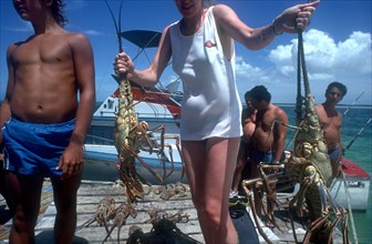 CUBA, Ciego de Avila, Cayo Guillermo, Woman on a jetty holding a deep sea catch