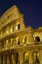 ITALY, LAZIO ,  ROME, The Colosseum exterior view at night of floodlit walls set against dark sky.