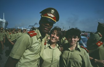 CUBA, Military, Two girls in soldiers uniforms stand with soldier