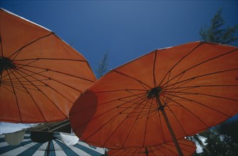 THIALAND, Phuket, Open red sun umbrellas seen from below against blue sky