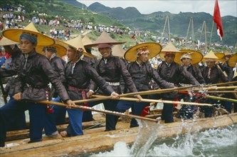 CHINA, Guizhou , Kaili, Oarsmen in traditional clothes rowing at dragon boat race