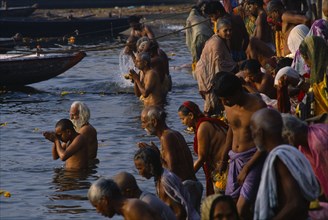 INDIA, Uttar Pradesh, Varanasi, Sivaratri Festival crowds praying and bathing in the River Ganges.