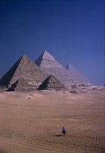 EGYPT, Cairo Area, Giza, The Pyramids with man on mule in foreground