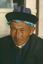 CHINA , Gansu , Dunhuang , Head and shoulders portrait of a Tibetan man wearing a hat