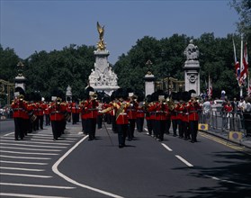 ENGLAND, London, Pageantry Marching guards band with The Victoria Memorial behind. Union Jack flags