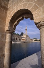TURKEY, Urfa, Sanliurfa  , Rizvaniye Camii and fish lake seen through stone archway