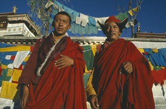 TIBET, Lhasa, Jokhang Temple, Two Buddhist monks in front of prayer flags