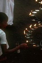 SRI LANKA, Anuradhapura, People lighting lamps during Wessac