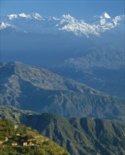 NEPAL, Nargakot , Mountain village on lower slopes with distant snow covered peaks beyond.