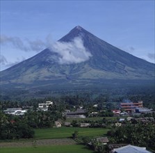 PHILIPPINES, Luzon Island, Legaspi, Mayon volcano with wispy cloud and village at the base