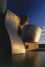 SPAIN, Basque Province, Bilbao, The Guggenheim Museum deatail with golden sunshine reflected at