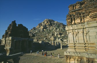 INDIA, Karnataka, Hampi, Achyutaraya Temple with Matanga Hill in the background and people walking