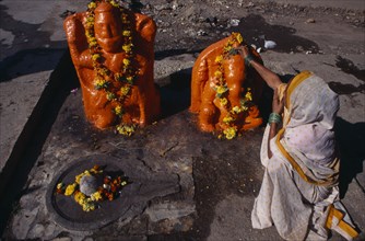 INDIA, Maharashtra, Nasik, Woman making votive offerings at Ganesh shrine