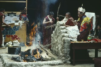 TIBET, Lhasa, Jokhang Temple, Chief Lama seated saying prayers over a fire at a festival