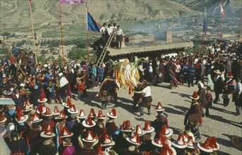 CHINA, Quinghai, Tongren, Tibetan festival with people wearing red tassled hats