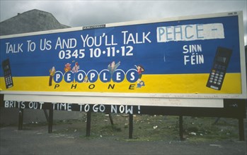 IRELAND,  North , Belfast, "Peoples Phone billboard advertisment poster on Falls Road dawbed with