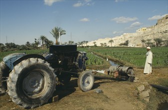 EGYPT, Nile Valley, Farming, Tractor driven irrigation in field with farmer watching