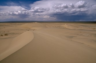 MONGOLIA, South Gobi , Vast expanse of desert sand dunes and cloudscape.