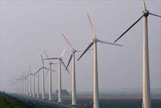 HOLLAND, Urk, Wind generators in a line in a misty landscape