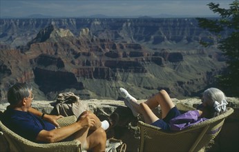 USA, Arizona, Grand Canyon, The North Rim with elderly couple seated