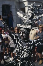 ENGLAND, London, Notting Hill Carnival dancer dressed in a black and white costume and face paint