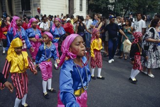 ENGLAND, London, Notting Hill Carnival. Children in costume blowing whistles during parade.