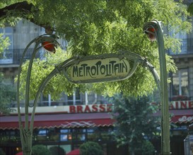 FRANCE, Ile de France, Paris, Art Nouveau `Metropolitain' sign in green wrought iron under tree
