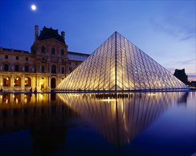 FRANCE, Ile de France, Paris, Louvre.  Glass pyramid and surrounding buildings floodlit at night