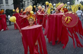 ENGLAND, London, "Notting Hill  Carnival. Little girl in red costume and flame shaped head-dress,