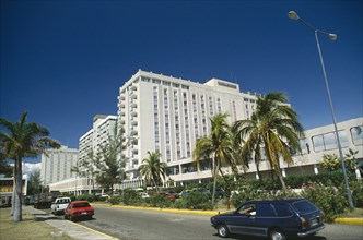 WEST INDIES, Jamaica  , Kingston, Downtown.  Oceana Hotel overlooking road lined by palm trees and