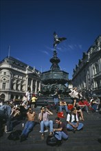 ENGLAND, London, Picadilly Circus with people congregating on the steps surrounding the base of