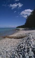 USA, Michigan, Lake Michigan, "View along shoreline with pebble beach, driftwood and breakwaters,