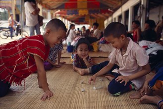 THAILAND, North, Mae Sai, Karen refugee boys playing a game with stones