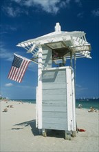 USA, Florida , Fort Lauderdale, Lifeguard tower on beach with American Stars and Stripes flag.